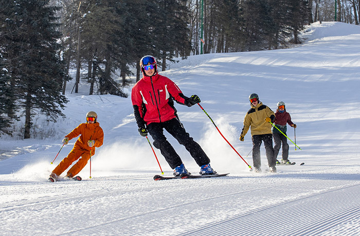 Skier kicking up powder with Lake Superior in the background